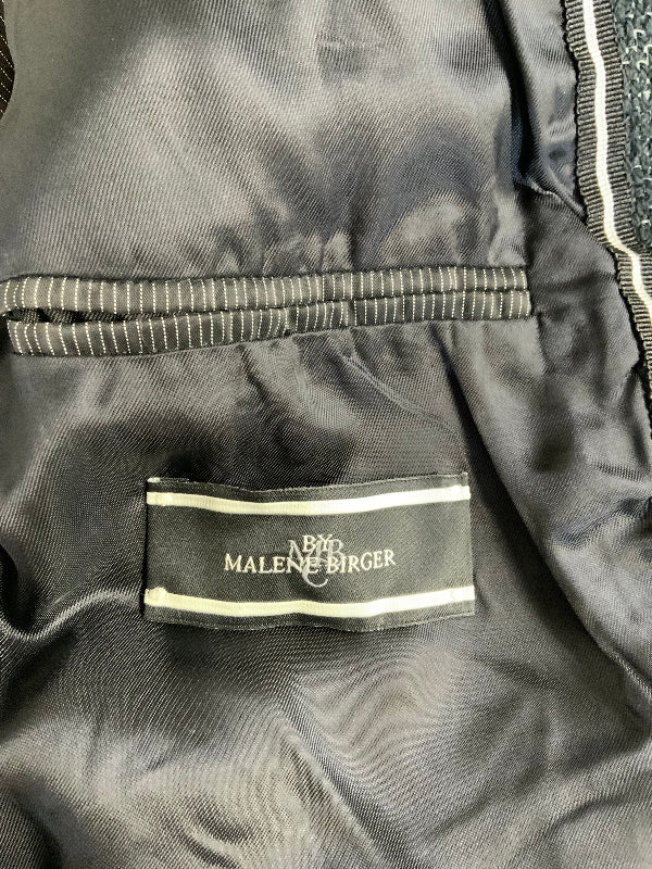 Close-up of a dark gray or black satin-lined garment interior with a visible brand label reading ‘BY MALENE BIRGER'.
