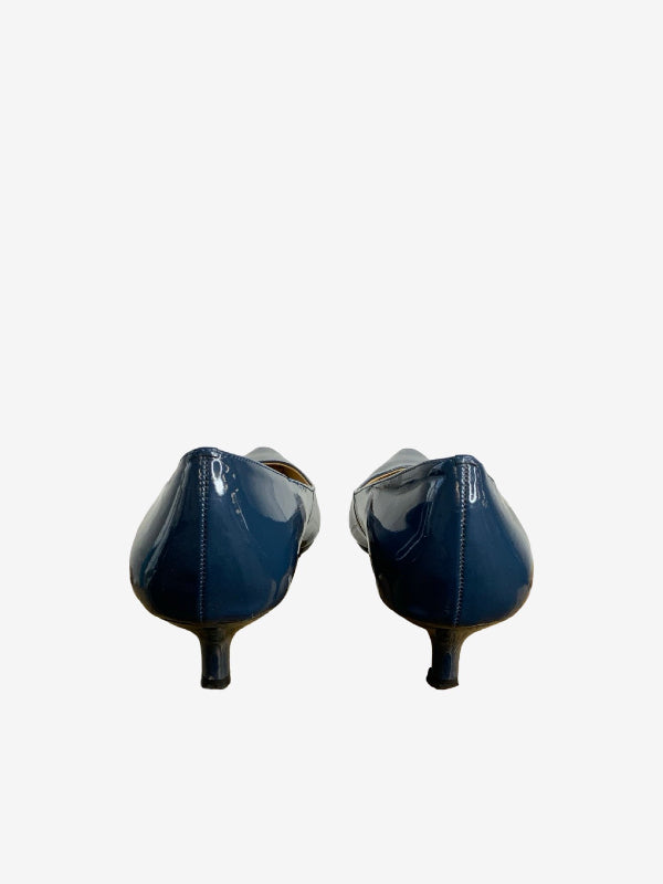 A pair of teal blue patent leather kitten heels shown from the back against a plain white background.