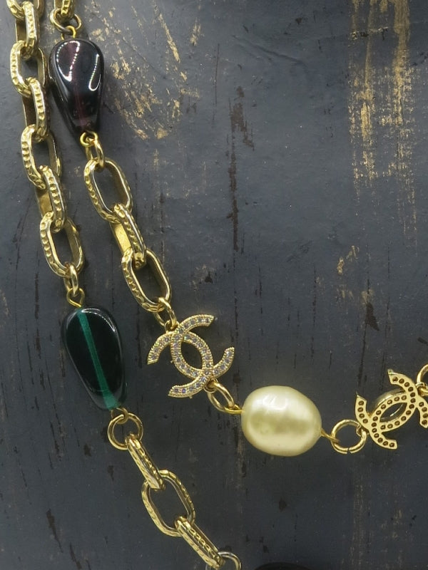 Chanel diamond CC charms on necklace with purple and green glass beads