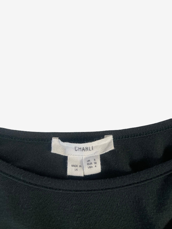 Close-up of the inside neckline of a green top, showing a white brand label that reads CHARLI.