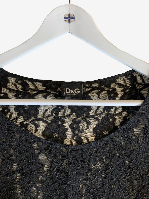 Close-up of a black lace top hanging on a white hanger with a D&G label visible at the neckline.