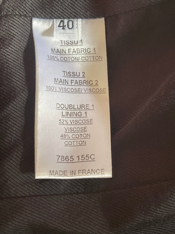 A close-up of a sewn-on fabric size and material label reading 40, with details for main fabric, lining, and cotton-viscose blends, placed on a dark brown textured garment.