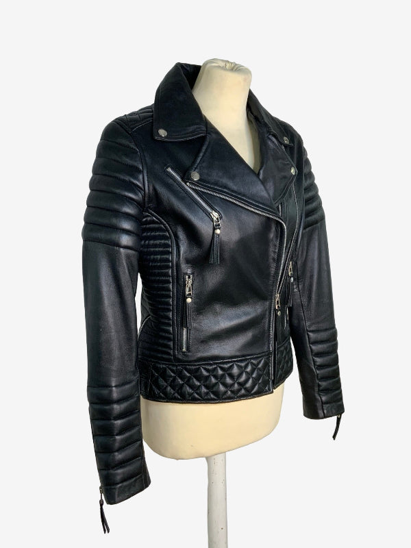 Black leather motorcycle jacket with quilted and ribbed details, displayed on a cream mannequin torso against a light gray background.