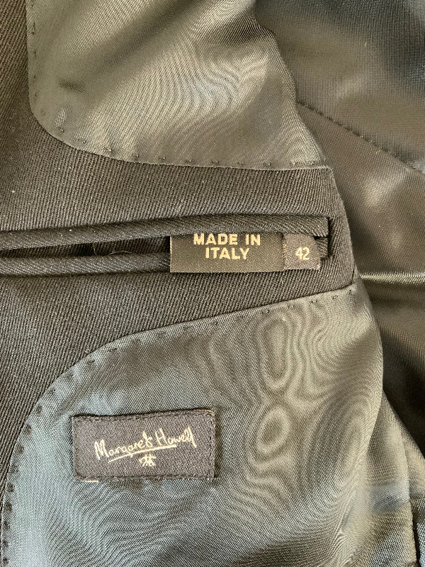 Close-up of a garment's interior lining showing a 'Made in Italy' size 42 label and a 'Margareta Hovland' brand patch.