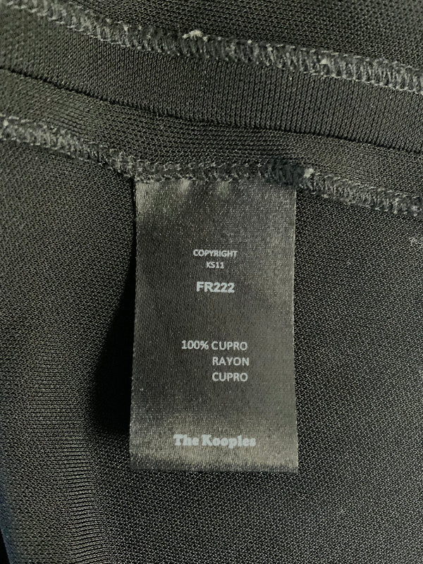 Close-up of a black garment interior label reading 'The Kooples' with size and material text including '100% CUPRO RAYON CUPRO'.