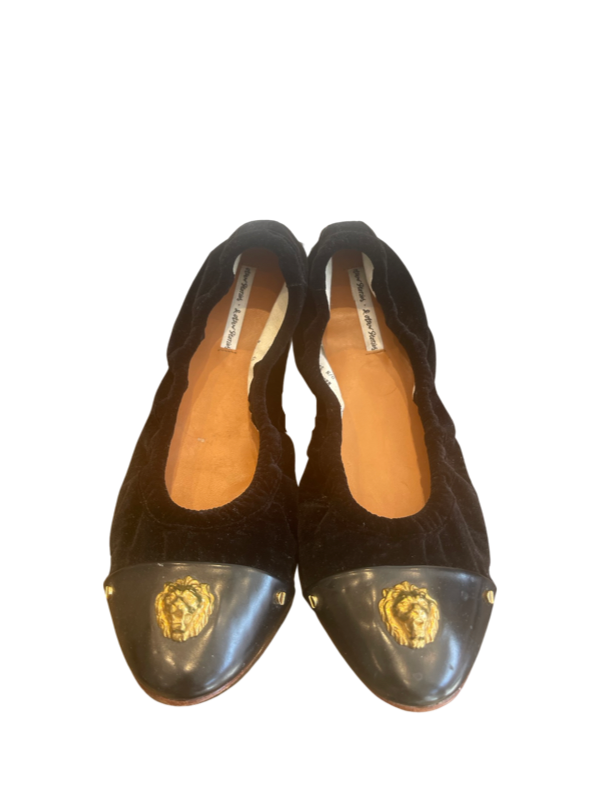 A pair of black suede And Other Stories flats with no visible wear on the soles, showing the side profile of the shoes with the brand's logo.