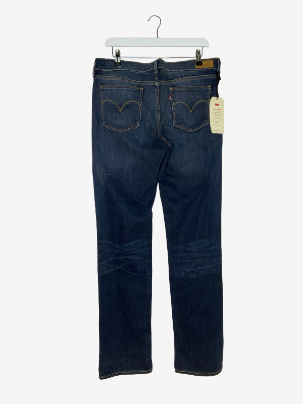 Back view of a pair of dark blue Levi's jeans hanging on a white hanger against a light gray background, showing the iconic curved stitching on the back pockets and a paper tag attached.