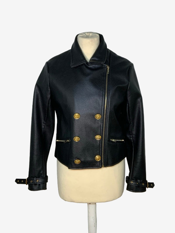 A black leather cropped jacket with gold-tone hardware, displayed on a cream mannequin torso against a light gray background.