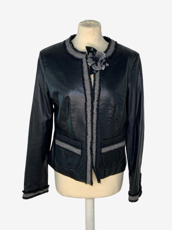 A black leather jacket with gray and white striped trim, displayed on a cream-colored mannequin torso against a light gray background.