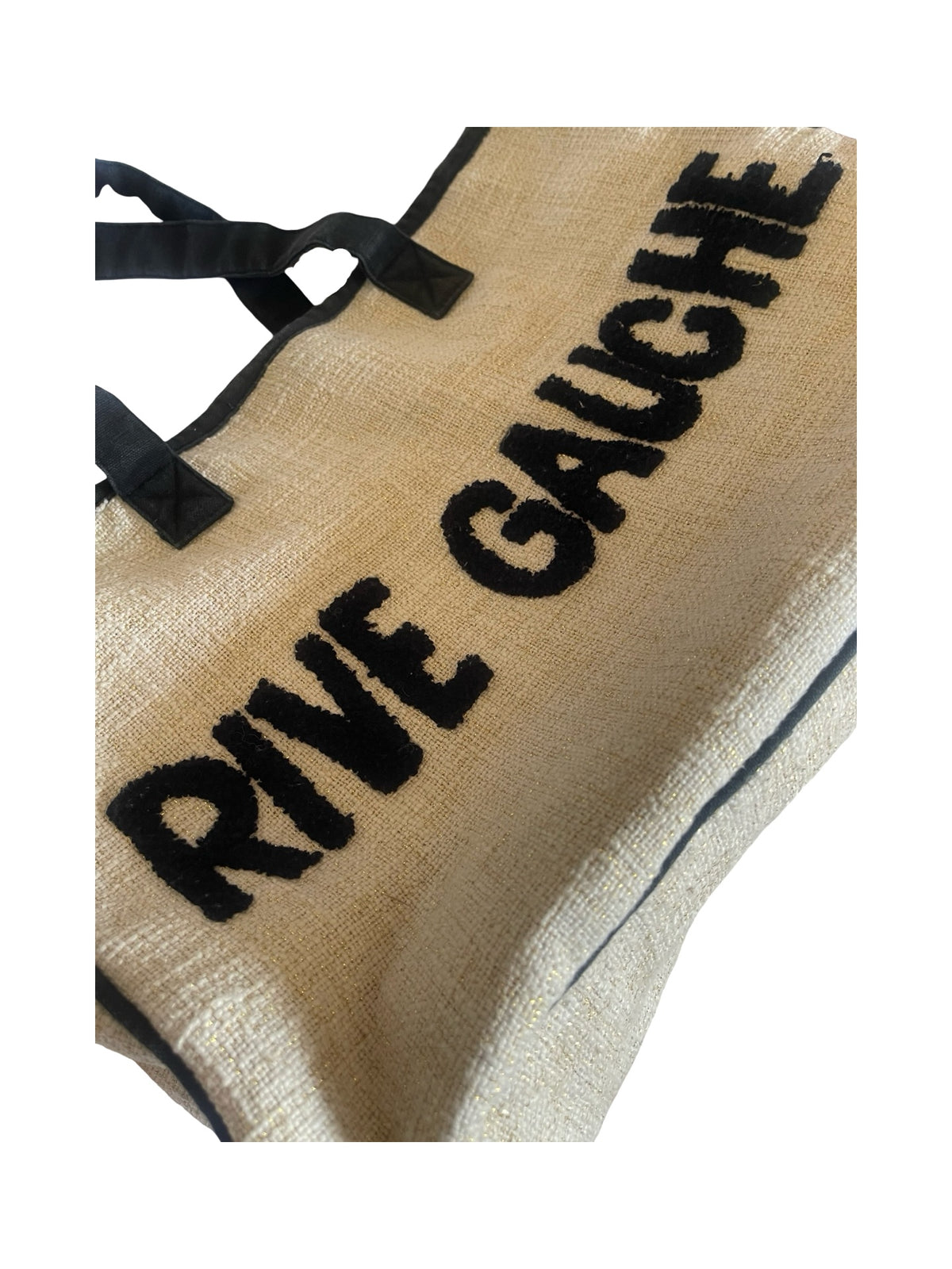 A close-up of a beige woven tote bag with black handles and black text reading 'RIVE GAUCHE' on a white background.