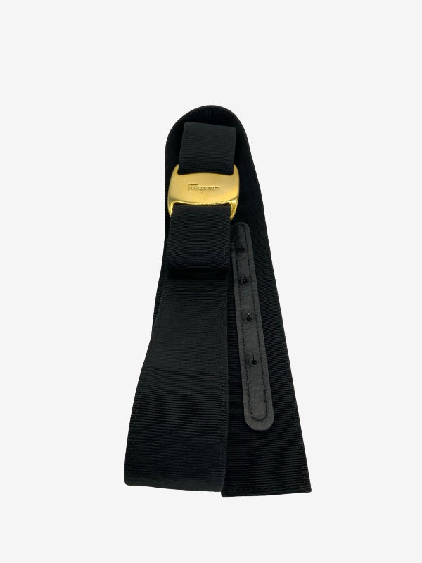 A black grosgrain waist belt with a gold metal buckle, shown against a plain light gray background.