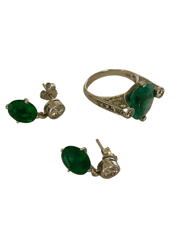A gold jewelry set featuring a ring and two matching stud earrings, each with a green oval gemstone and small clear accent stones, shown on a plain white background.