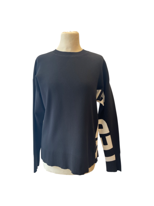 Black jumper with white writing down one side and under arm