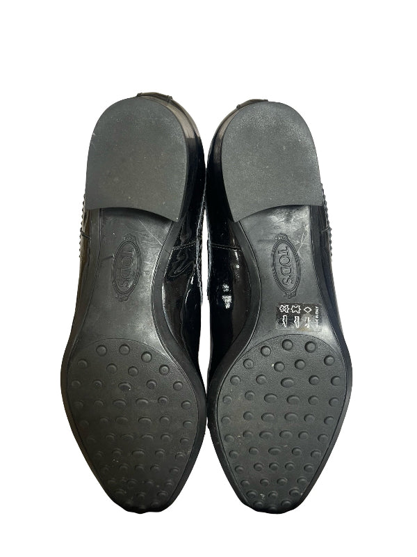 A pair of black leather dress shoes shown from the sole side, displaying the tread pattern and size markings on a plain white background.
