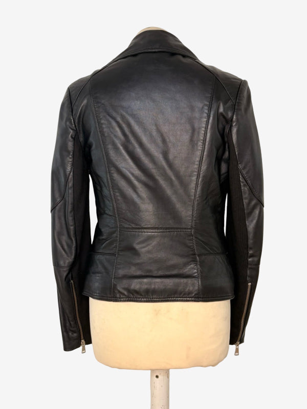 A black leather jacket shown from the back on a cream-colored dress form mannequin, against a plain white background.