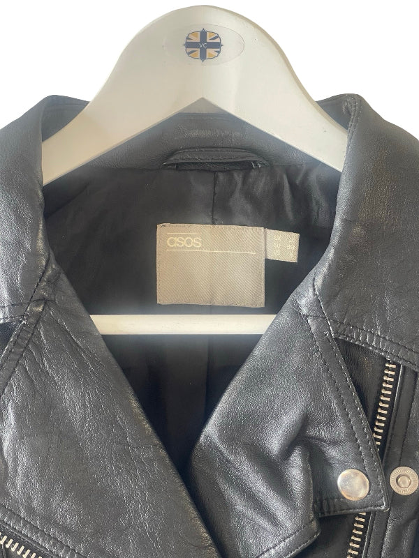A black leather motorcycle jacket with a silver zipper and snap buttons, hanging on a white hanger with a  ASOS  logo.