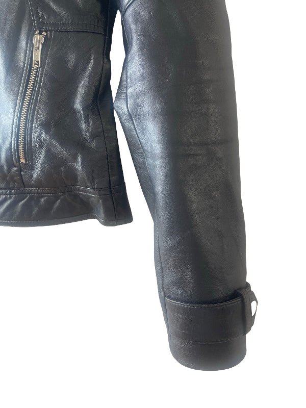 Close-up of a black leather jacket sleeve with a cuff strap and a zippered pocket on the upper chest, shown against a plain white background.
