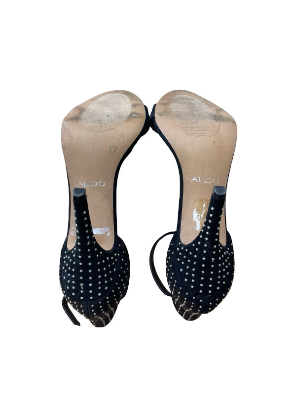 A pair of black pointed-toe heels with silver rhinestone studs embellishments on the uppers, shown from the sole side against a white background. The brand name 'ALDO' is visible on the beige sole
