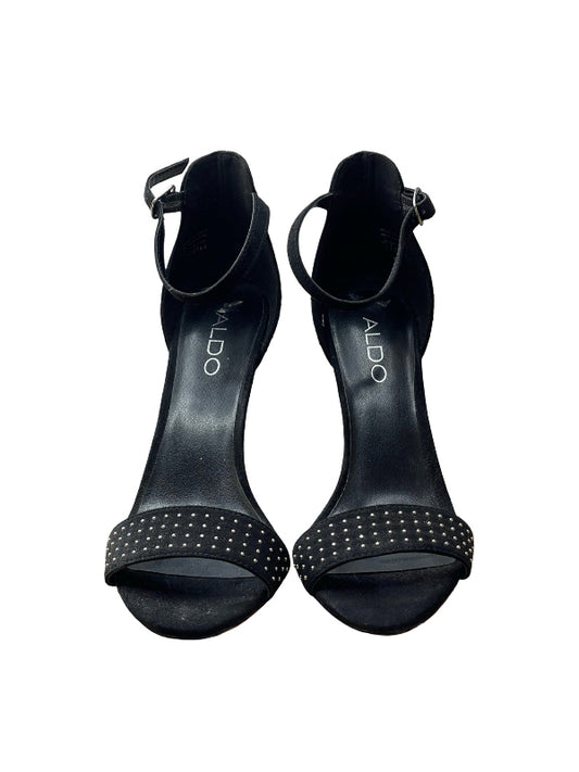 A pair of black open-toe heeled sandals with ankle straps and silver stud detailing on the toe straps, shown against a plain white background.