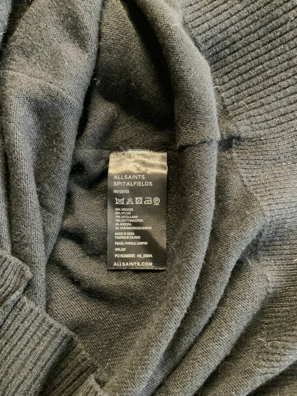 Close-up of a black  ribbed knit garment showing the inner neck label, which reads AllSaints Spitalfields.