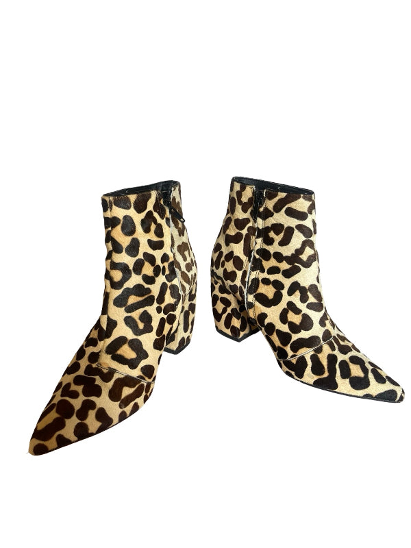 A pair of pointed-toe ankle boots with a beige, brown, and black leopard print pattern, shown against a plain white background.