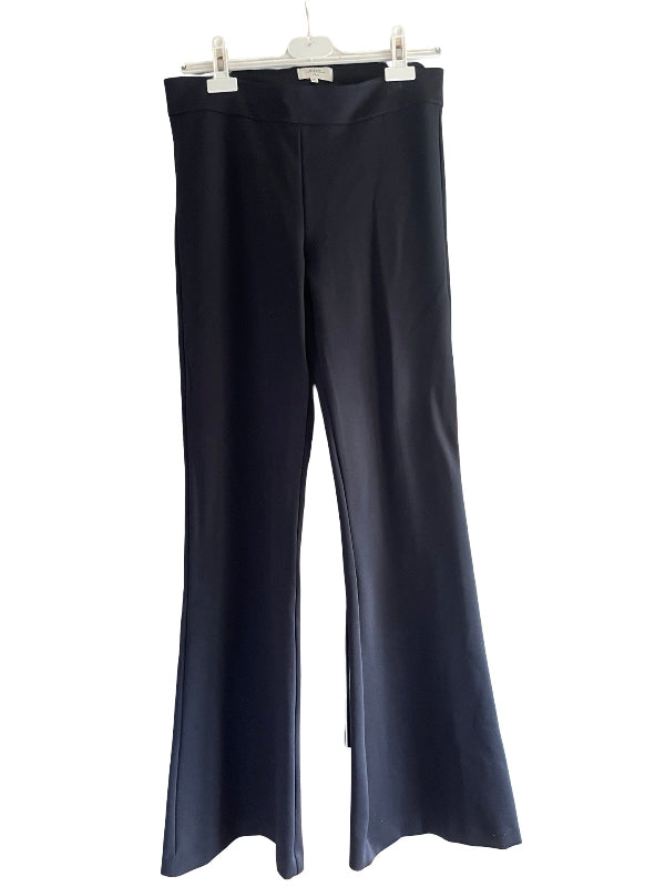 A pair of dark black wide-leg pants hanging from a white plastic hanger against a plain white background.