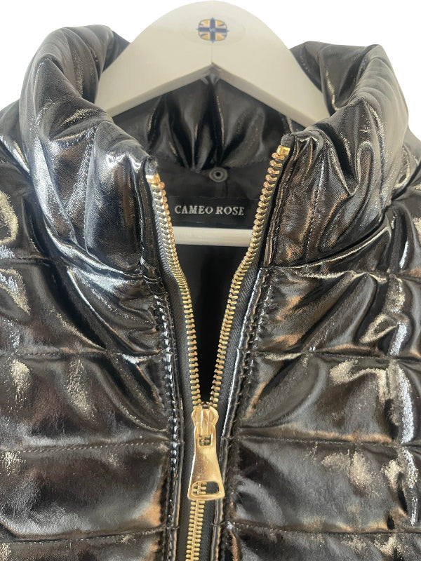 A close-up of a shiny black quilted puffer jacket on a white hanger, featuring a gold zipper and a visible 'CAMEO ROSE' brand label.
