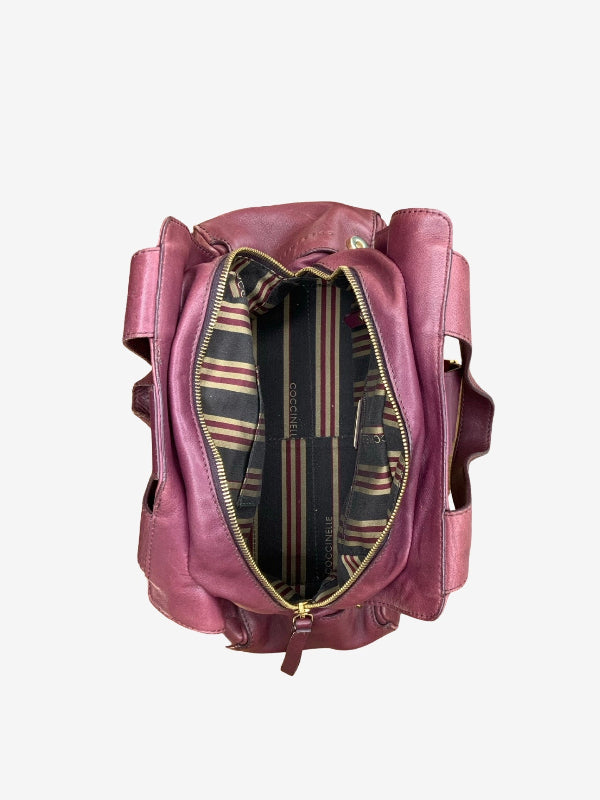 A dusty rose leather bag shown from a top-down view with its main compartment open, revealing a striped interior lining in black, green, and beige with gold zippers.