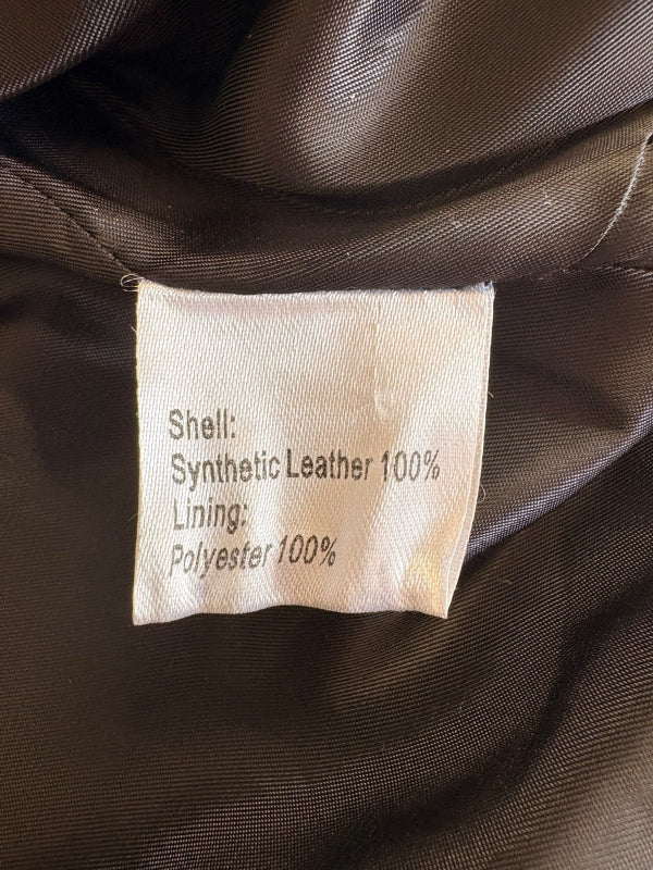 Close-up of a garment's interior label showing material composition: Shell is Synthetic Leather 100% and Lining is Polyester 100% on a black satin-like fabric.