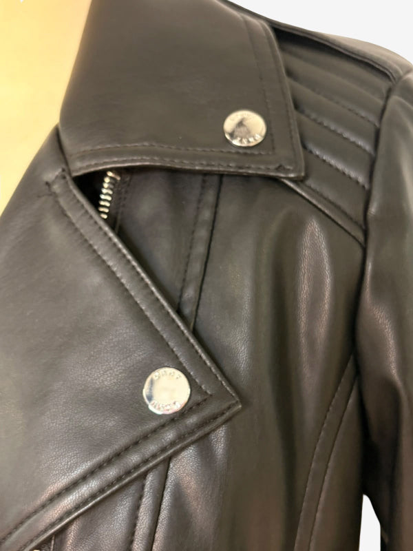 Close-up of a black faux-leather biker jacket featuring an asymmetrical zipper, silver snap buttons, and ribbed shoulder detailing.