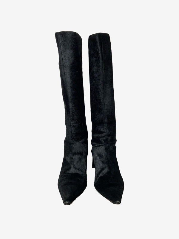 A pair of black knee-high boots with a textured, velvety furry finish and pointed toes, shown against a plain light gray background.