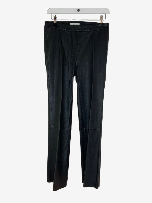 Black wide-leg kick flare  trousers hanging on a white hanger against a light gray background.