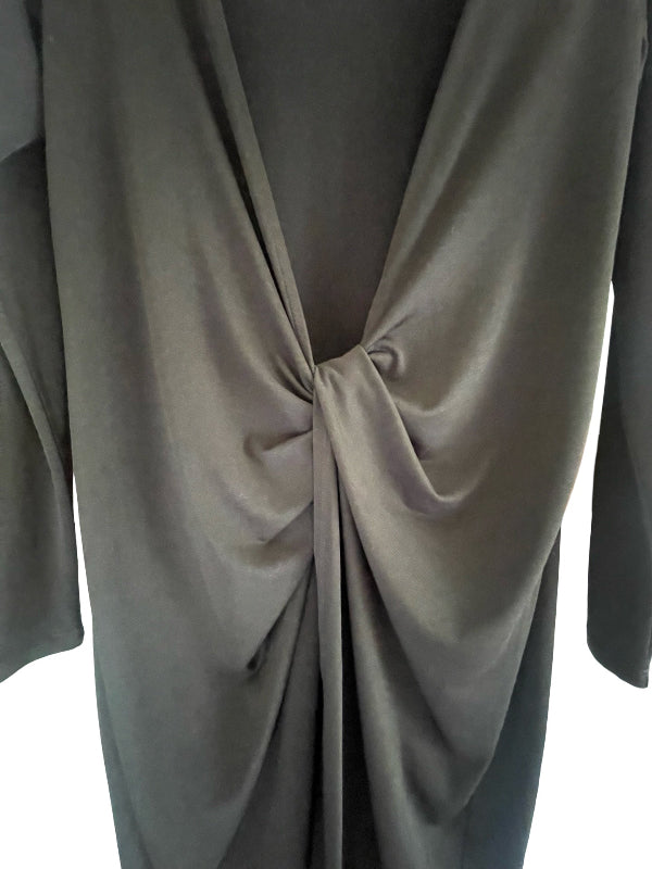 A close-up of a draped, long-sleeved wrap-style top or dress in a muted  black color, featuring a twisted knot detail at the center front.