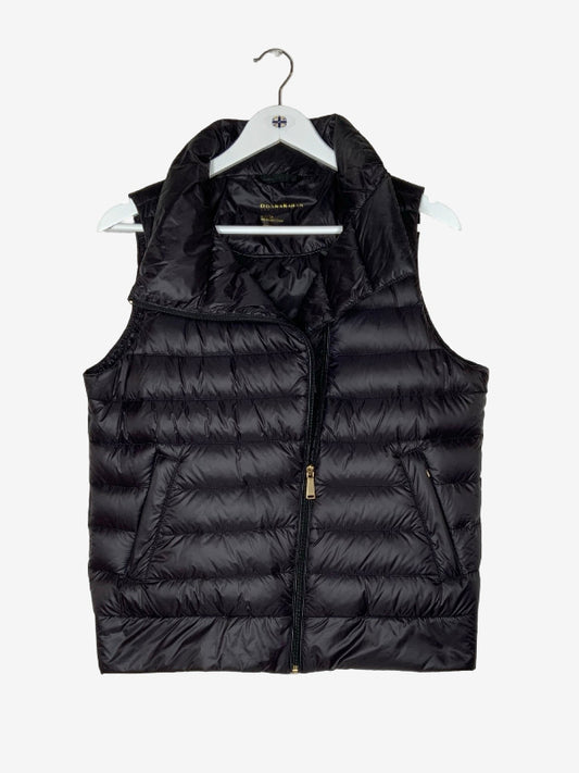 A black puffer vest with horizontal quilting, a full front zipper, and zippered side pockets, hanging on a white hanger against a light gray background.