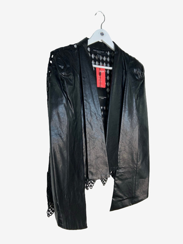 A black faux-leather open-front cape with shoulder cutouts and lace-up detailing, hanging on a white hanger against a light gray background.