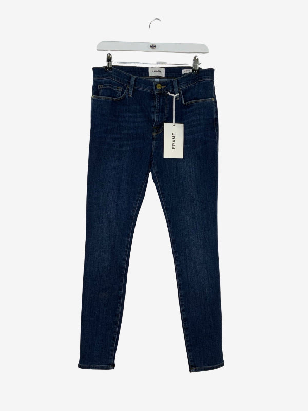 Dark blue slim-fit denim jeans hanging from a white hanger with a white brand tag, shown against a plain light gray background.