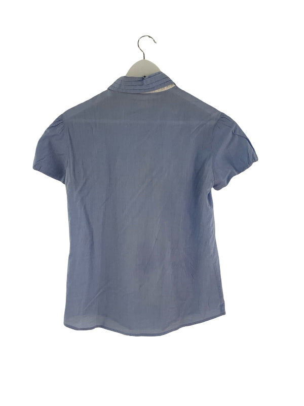 A short-sleeve collared blouse in a dusty slate blue color, shown from the back on a hanger against a plain white background.