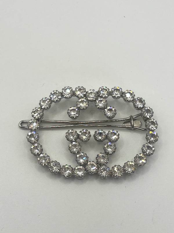 A silver-tone double G buckle hair slide barrette  with clear faceted rhinestones, displayed on a plain light gray background.