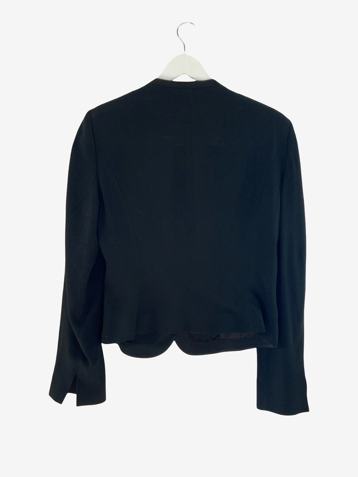 A black long-sleeve cropped jacket or shrug displayed on a white hanger against a plain white background.