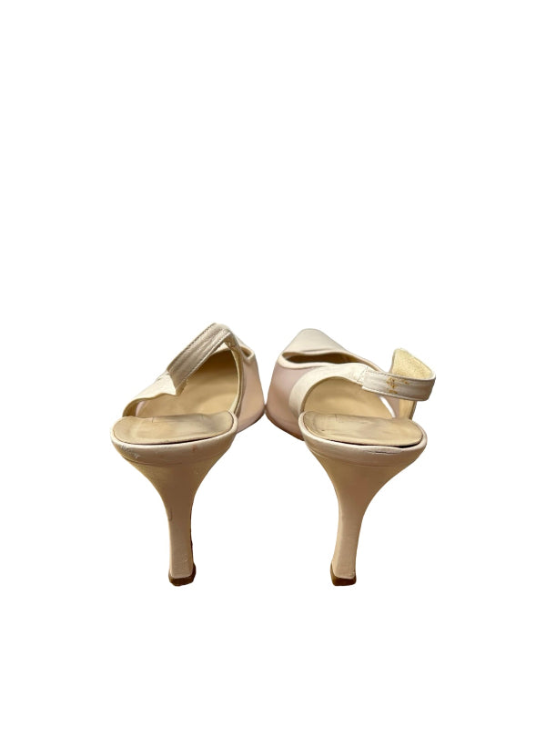 A pair of women's high-heeled slingback sandals in a light beige or cream satin-like material, shown from the back on a plain white background.