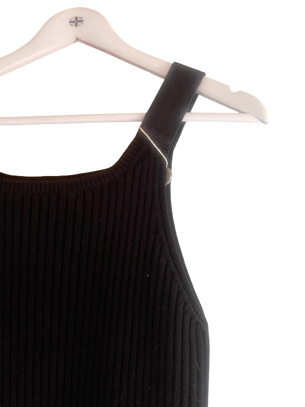 A close-up of a black ribbed knit sleeveless top or dress hanging on a white plastic hanger against a white background.
