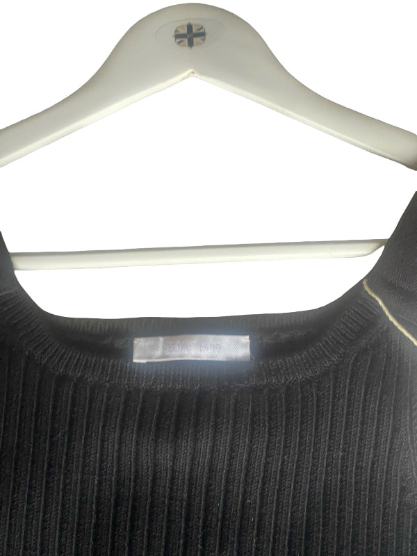 A close-up of a black ribbed knit top on a white plastic hanger against a white background.