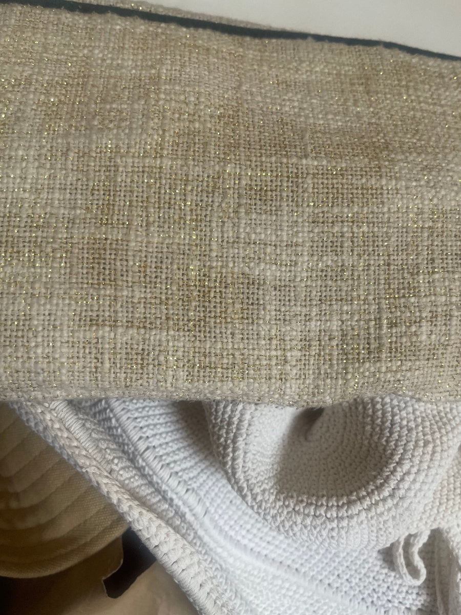 Close-up of a textured beige woven fabric next to a white knit material, showing the detailed weave and soft texture.