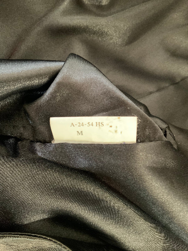 Close-up of a black satin or silk garment interior with a small white size label reading A-24-54 HS M.