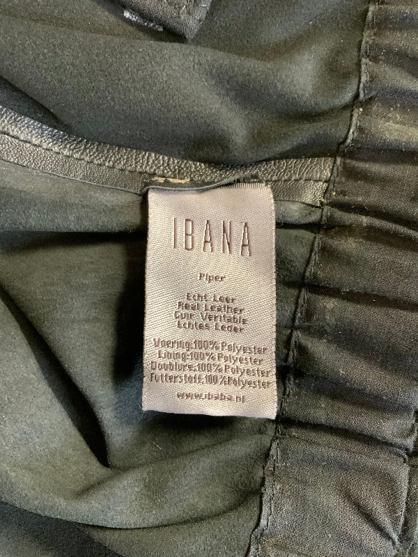 Close-up of a garment's interior label reading IBANA, showing stitched fabric in a muted olive-gray color.