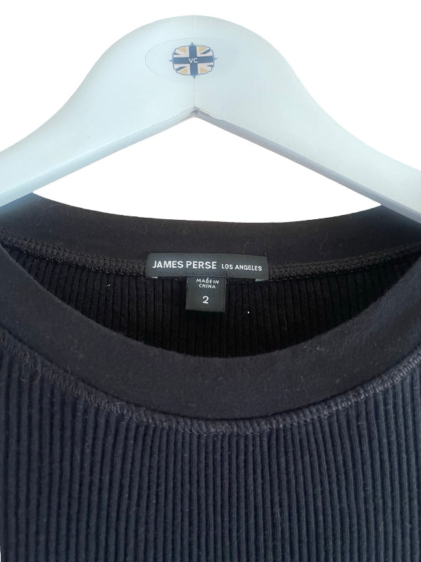 Close-up of a black ribbed knit crewneck sweater hanging on a white hanger, showing the James Perse Los Angeles neck label.