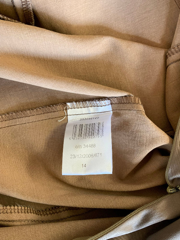 Close-up of a beige/tan garment interior showing a sewn-in size tag with barcode and text, plus zipper and fabric details.