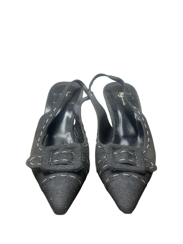 A pair of dark denim pointed-toe slingback pumps with a decorative square buckle detail on the instep and contrast white stitching, shown against a plain white background.