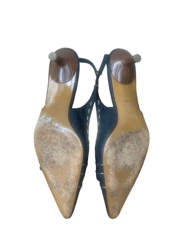 A pair of women's pointed-toe slingback heels shown from the bottom, featuring a black suede upper and a light tan patent leather sole with a dark brown heel insert.