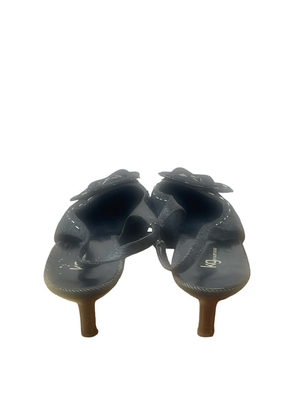 A pair of women's denim sling back shoes sandals with low kitten heels and decorative covered buckle detail on the front shown from the back on a white background.